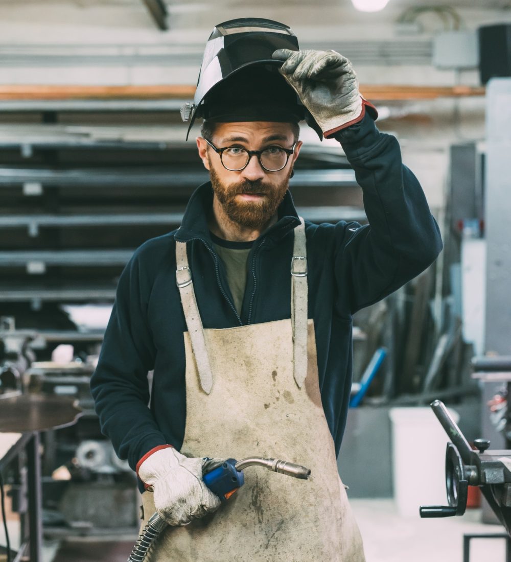 portrait-of-metalworker-holding-welding-torch-in-forge-workshop.jpg